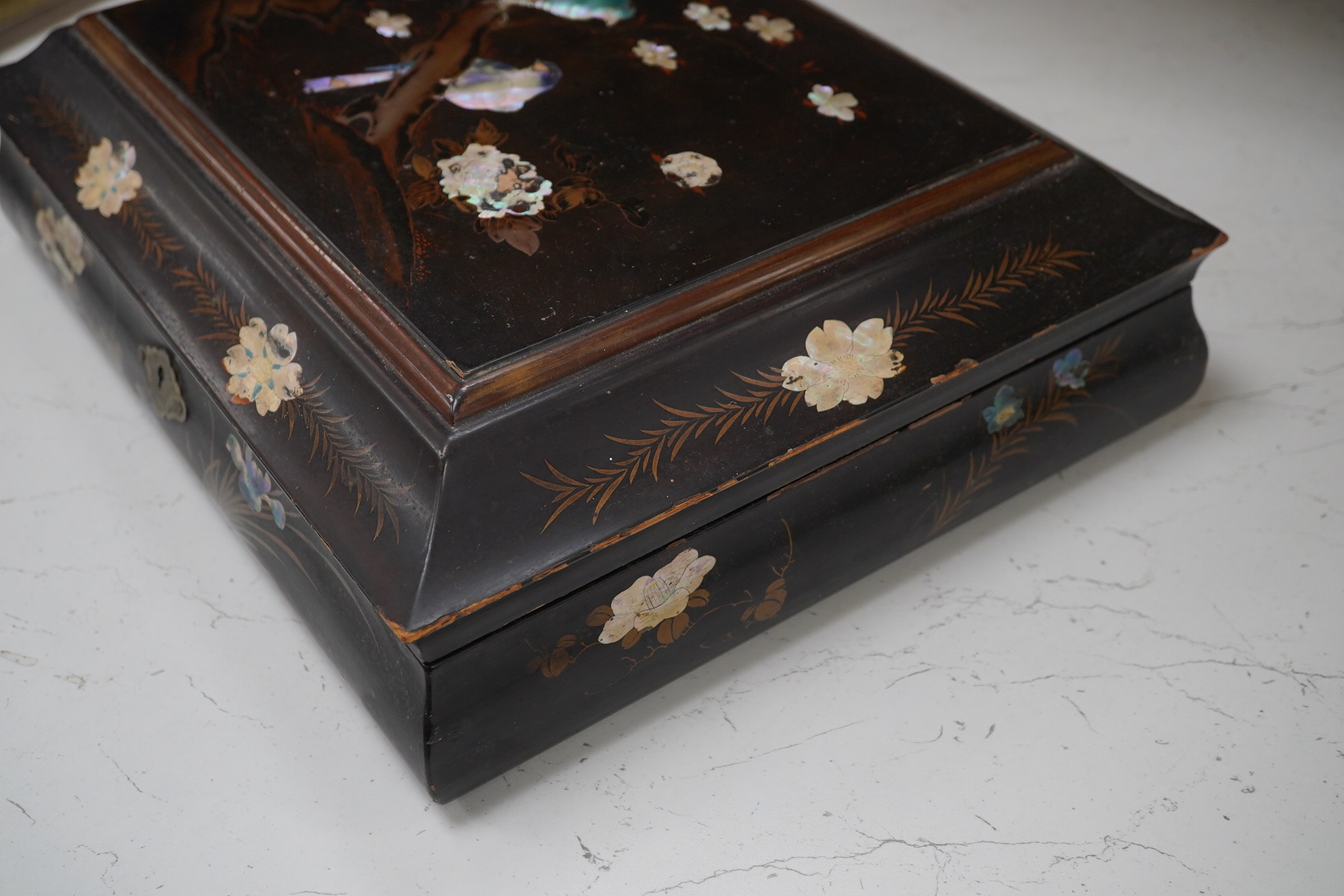 A Japanese lacquered box with mother of pearl inlay of birds and flowers, 35.5cm wide. Condition - worn on the outside to be expected, inside good